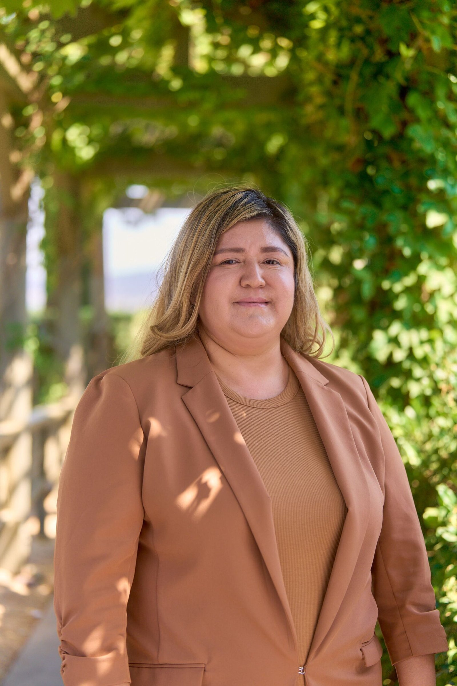 Jessica Alencaster Avendano - Housekeeping Manager smiling outdoors wearing a brown blazer.