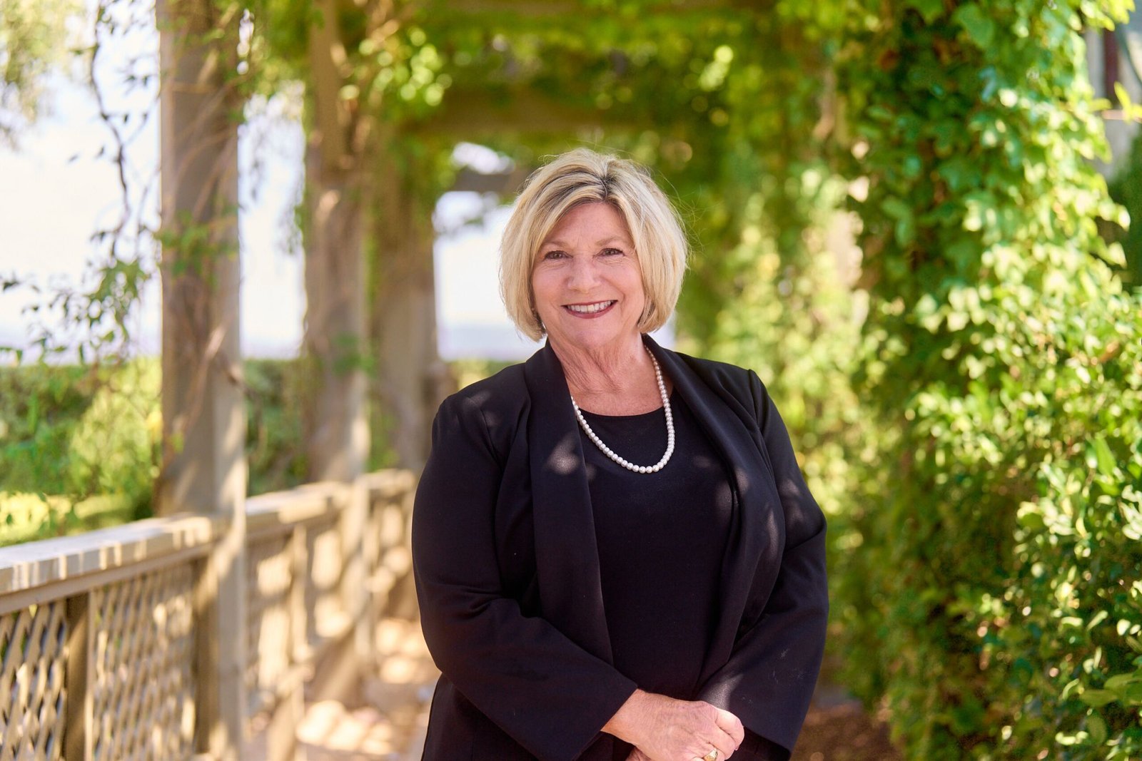 Photo of Mindy Smith - Special Events Manager for Ponte smiling outdoors wearing a black blazer.