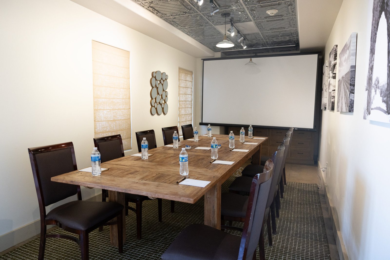 A photo of our Decanter Room with a long table and chairs set up in front of a projector.